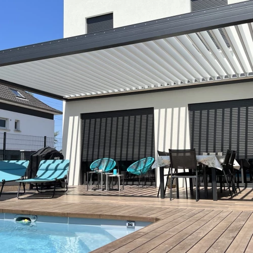 Pergola bioclimatique Éléance et terrasse en Thermofrêne autour d’une piscine à Haguenau – BH Solutions